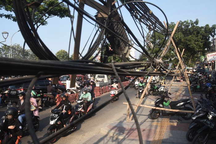 Kabel utilitas semrawut di Bekasi Sejumlah pengendara motor melintas di samping kabel utilitas yang semrawut di Jalan Ir H Juanda, Bekasi, Jawa Barat, Senin (7/8/2023). Belum ada penanganan dari pemerintah daerah setempat terkait kondisi tersebut yang berpotensi membahayakan pengguna jalan. ANTARA FOTO/ Fakhri Hermansyah/aww.