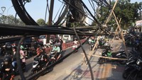 Sejumlah pengendara motor melintas di samping kabel utilitas yang semrawut di Jalan Ir H Juanda, Bekasi, Jawa Barat, Senin (7/8/2023). 