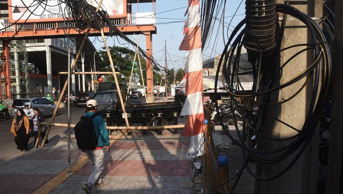 Kabel utilitas semrawut di Bekasi Sejumlah pengendara motor melintas di samping kabel utilitas yang semrawut di Jalan Ir H Juanda, Bekasi, Jawa Barat, Senin (7/8/2023). Belum ada penanganan dari pemerintah daerah setempat terkait kondisi tersebut yang berpotensi membahayakan pengguna jalan. ANTARA FOTO/ Fakhri Hermansyah/aww.