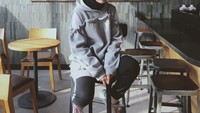 Nissa pernah berpose keren di sebuah kafe. Ia tampak duduk di salah satu kursi dengan latar belakangnya adalah lukisan yang keren. Foto: Instagram @nissa_sabyan