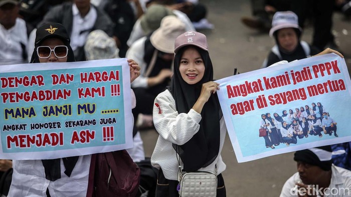 Ribuan pegawai honorer menggelar aksi meminta diangkat menjadi ASN di depan Gedung DPR, Jakarta. Berbagai poster berisi curhatan mereka bawa.