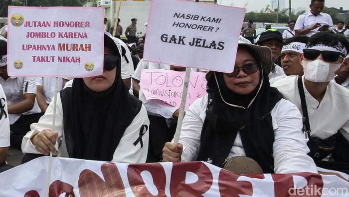 Ribuan pegawai honorer menggelar aksi meminta diangkat menjadi ASN di depan Gedung DPR, Jakarta. Berbagai poster berisi curhatan mereka bawa.