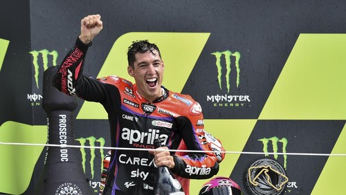 Spains rider Aleix Espargaro of the Aprilia Racing celebrates with trophy on the podium after winning the MotoGP race of the British Motorcycle Grand Prix at the Silverstone racetrack, in Silverstone, England, Sunday, Aug. 6, 2023. (AP Photo/Rui Vieira)