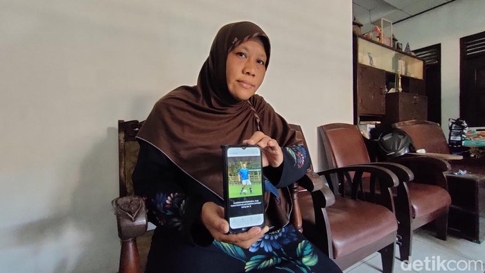 Sulistyawati menunjukkan foto suaminya, Sadmoko Budi Sulistyo, yang meninggal ditabrak mobil di Wates. Foto diambil di rumah korban, Kedunggong, Wates, Senin (7/8/2023).
