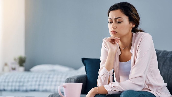 Cropped shot of a young woman looking bored while sitting at home