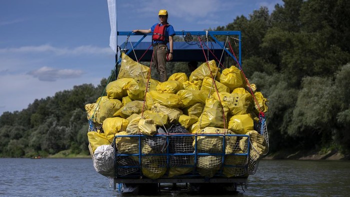 Volunteers selectively sort the collected rubbish after they arrived to the campsite for that day on Tuesday, Aug. 1, 2023. The annual Plastic Cup competition has gathered around 330 tons of waste from the Tisza since 2013. Their aim is to preserve Hungary's natural environment, but also to head off a mounting global plastic waste crisis by cutting it off early in the cycle. (AP Photo/Denes Erdos)