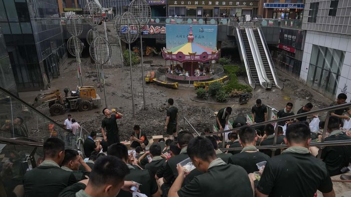 Banjir di China Surut, Warga Bersih-bersih Toko Workers clear mud water from an apartment entrance gate in the aftermath of flood waters from an overflowing river in the Mentougou district on the outskirts of Beijing, Monday, Aug. 7, 2023. Rain continued to pelt northeastern China in the wake of Typhoon Doksuri, as authorities reported more fatalities and missing people while evacuating thousands more. (AP Photo/Andy Wong)