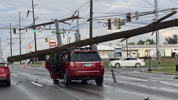 A fallen pole rests on a car at the intersection of Route 140 and Market Street in Westminster., Md., on Monday, Aug. 7, 2023. (Baltimore Sun Staff/The Baltimore Sun via AP)