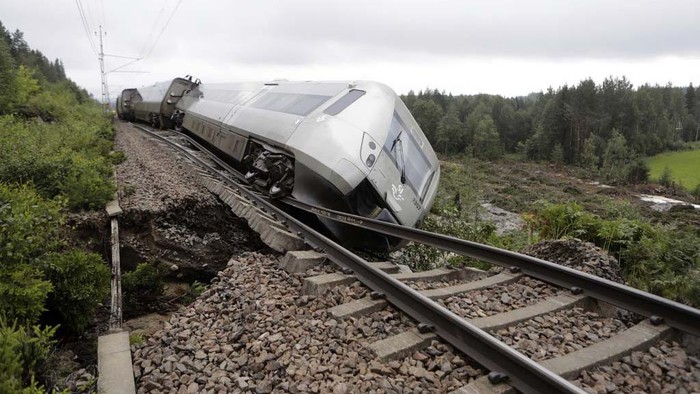 A passenger train carrying 120 passengers is seen derailed between Iggesund and Hudiksvall in Sweden, Monday Aug. 7, 2023. Three people had been taken to hospital in Sweden when two of a train's passenger cars went off the tracks in Hudiksvall, north of Stockholm, police said. The derailment happened because ”the embankment has been undermined by the heavy rain and landslides,“ they said, adding that the extent of their injuries is unclear. (Mats Andersson/TT News Agency via AP)