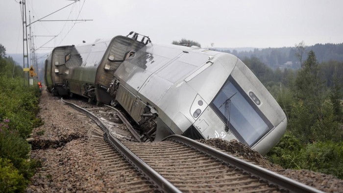 A passenger train carrying 120 passengers is seen derailed between Iggesund and Hudiksvall in Sweden, Monday Aug. 7, 2023. Three people had been taken to hospital in Sweden when two of a train's passenger cars went off the tracks in Hudiksvall, north of Stockholm, police said. The derailment happened because ”the embankment has been undermined by the heavy rain and landslides,“ they said, adding that the extent of their injuries is unclear. (Mats Andersson/TT News Agency via AP)