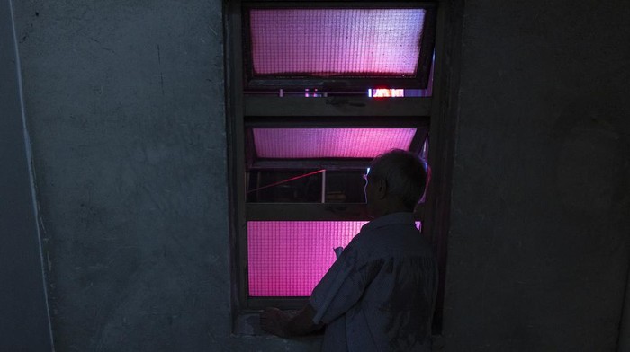 Workers remove a neon sign that was hung on Tai Ping Koon restaurant building since 1964 in Hong Kong, Sunday, Aug. 6, 2023. Once ubiquitous in Hong Kong's streetscapes, the city's iconic neon signs are disappearing due to tightening government regulations. (AP Photo/Louise Delmotte)