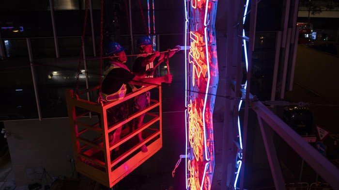 Papan Neon Ikonik yang Hiasi Malam di Hong Kong Bakal Menghilang Workers remove a neon sign that was hung on Tai Ping Koon restaurant building since 1964 in Hong Kong, Sunday, Aug. 6, 2023. Once ubiquitous in Hong Kong's streetscapes, the city's iconic neon signs are disappearing due to tightening government regulations. (AP Photo/Louise Delmotte)