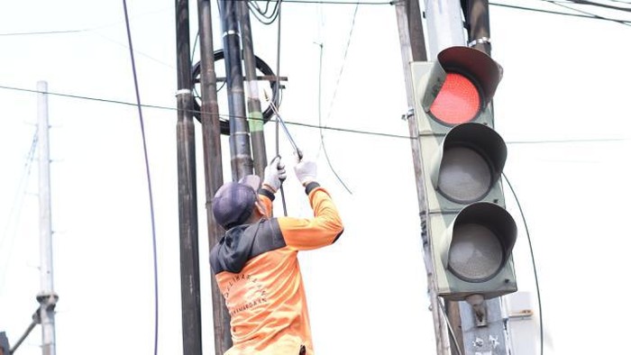 Petugas Dinas PUPR Kota Bogor memotong kabel fiber optik yang menjuntai di Cimahpar dan Simpang Pomad, Selasa (8/8/2023).