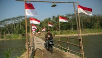 Seorang pengendara sepeda motor melintas di atas jembatan sesek bambu yang membelah Sungai Progo di Pajangan, Bantul, DI Yogyakarta, Selasa (8/8/2023). 