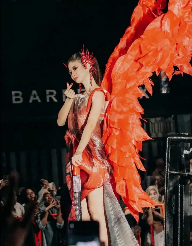 Yuki Kato juga memakai aksesori sayap merah yang membentang di bagian belakang. Foto: Instagram @prillylatuconsina @cassava.photography/@di3di3