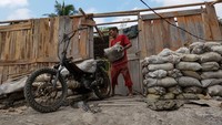 Penambang membawa hasil galian tambang, sebelum melakukan pembongkaran bedeng dan menimbun lubang galian tambang secara sukarela di Desa Pancurendang, Ajibarang, Banyumas, Jawa Tengah, Selasa (8/8/2023). Penambang yang melakukan pembongkaran secara sukarela diijinkan untuk membawa hasil galian tambang sebagai kompensasi agar tidak melanjutkan kegiatan penambangan emas ilegal di Kabupaten Banyumas, Jateng. 