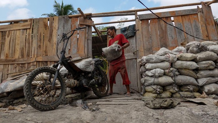 Penambang membawa hasil galian tambang, sebelum melakukan pembongkaran bedeng dan menimbun lubang galian tambang secara sukarela di Desa Pancurendang, Ajibarang, Banyumas, Jawa Tengah, Selasa (8/8/2023). Penambang yang melakukan pembongkaran secara sukarela diijinkan untuk membawa hasil galian tambang sebagai kompensasi agar tidak melanjutkan kegiatan penambangan emas ilegal di Kabupaten Banyumas, Jateng. ANTARA FOTO/Idhad Zakaria.