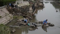 Setelah banjir menyurut, warga mulai membersihkan barang-barang mereka dari lumpur.  