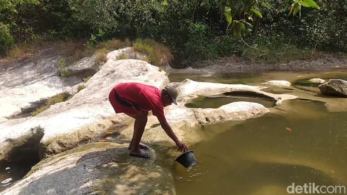 warga mengambil air di sungai marmoyo jombang
