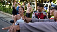 Polisi menghentikan wisatawan mancanegara yang tidak mengenakan helm saat sosialisasi tertib berlalu lintas di kawasan Seminyak, Badung, Bali, Selasa (8/8/2023). 