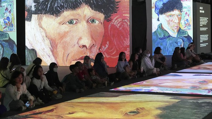 Masuk ke Dunia Van Gogh Alive di Jakarta A couple watch visual animated montage of notable works by artist Vincent Van Gogh at the