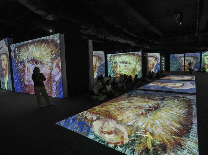 A couple watch visual animated montage of notable works by artist Vincent Van Gogh at the Van Gogh Alive exhibition at Taman Anggrek mall in Jakarta, Indonesia Wednesday, Aug. 9, 2023. (AP Photo/Tatan Syuflana)
