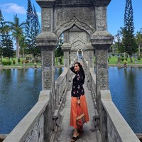 Ibu satu anak ini memadukan kebayanya dengan rok oranye terang. Penampilannya simpel hanya dilengkapi sandal hitam dan tas dari kain tenun. Foto: Instagram/@maudykoesnaedi