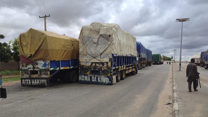 Nigeria Tutup Perbatasan Darat Buntut Kudeta Niger Stranded trucks with goods are seen at the border between Nigeria and Niger in Jibia, Nigeria, Monday, Aug. 7, 2023. The West Africa regional bloc's decision to shut borders with Niger in sanctioning the country's coup plotters is affecting businesses and locals in Nigerian towns where economic activities with Nigeriens had boomed for years. (AP Photo/Mohammed Babangida)