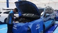 Mekanik sedang mengecek mesin mobil di dealer baru Subaru.