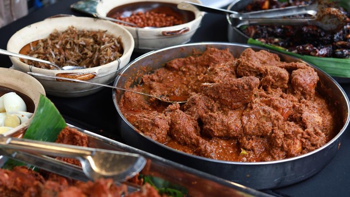 Various choice of Nasi Lemak dishes, chicken rendang, ayam goreng berempah, anchovies, roasted peanuts, hard boiled egg and spicy sambal at market stall.