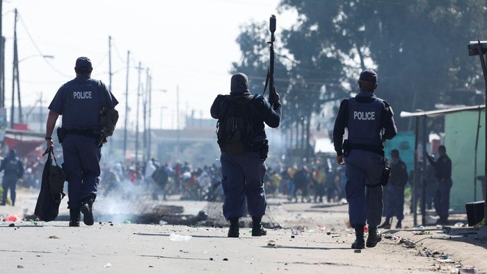 Residents of Masiphumelele throw stones at law enforcement officers amidst an ongoing strike by taxi operators against traffic authorities in Cape Town, South Africa, August 8, 2023. REUTERS/Esa Alexander