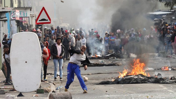 5 Orang Tewas dalam Demo Berdarah Sopir Taksi di Afrika Selatan Residents of Masiphumelele throw stones at law enforcement officers amidst an ongoing strike by taxi operators against traffic authorities in Cape Town, South Africa, August 8, 2023. REUTERS/Esa Alexander