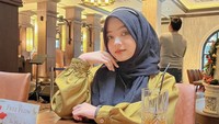 Jangan sama aku, aku sukanya makan, kata Anggi di keterangan fotonya. Tampak ada udang telur asin yang ia siap makan usai berfoto. 