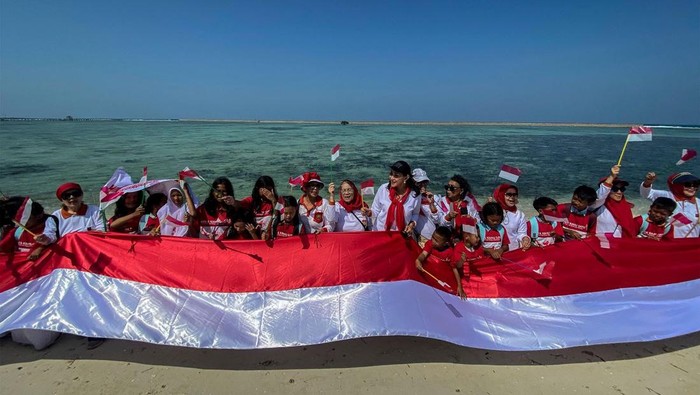 Ketua Umum Kowani Giwo Rubianto Wiyogo bersama pengurus dan anak anak sekolah membentangkan bendera merah putih sepanjang 25 meter di pantai Pulau Pramuka, Kepulauan Seribu, Kamis (10/8/23). Kowani memperingati hari Konservasi Alam Nasional 2023 dengan aksi menanam mangrove, terumbu karang dan pelepasan tukik untuk edukasi upaya perlindungan sumber daya alam serta ekosistemnya sebagai penyangga hidup berkelanjutan.