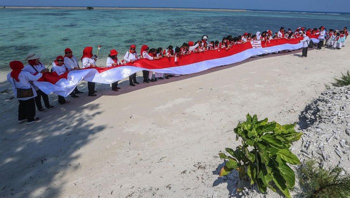 Ketua Umum Kowani Giwo Rubianto Wiyogo bersama pengurus dan anak anak sekolah membentangkan bendera merah putih sepanjang 25 meter di pantai Pulau Pramuka, Kepulauan Seribu, Kamis (10/8/23). Kowani memperingati hari Konservasi Alam Nasional 2023 dengan aksi menanam mangrove, terumbu karang dan pelepasan tukik untuk edukasi upaya perlindungan sumber daya alam serta ekosistemnya sebagai penyangga hidup berkelanjutan.