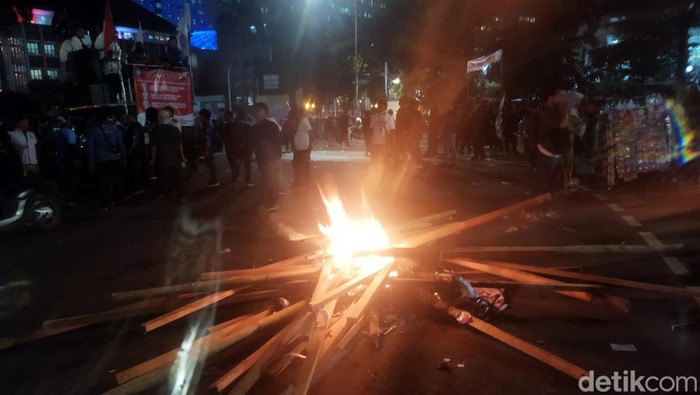 Massa buruh bakar ban dan potongan bambu di bundaran Patung Kuda, Jakpus.