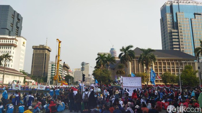 Massa buruh duduk-duduk di Patung Kuda hingga perempatan Kebon Sirih, Jalan MH Thamrin, Jakarta Pusat.