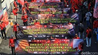 Massa buruh juga membentangkan spanduk saat long march menuju Patung Kuda.  