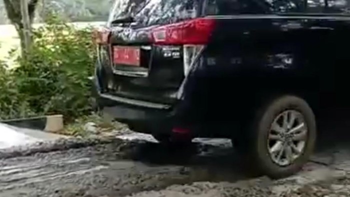 Mobil dinas melintasi jalan yang baru dicor di Musi Waras. (Foto: Istimewa)