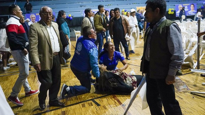 Supporters of presidential candidate Fernando Villavicencio take cover after he was shot and killed at the end of a campaign rally outside a school in Quito, Ecuador, Wednesday, Aug. 9, 2023. (API via AP)