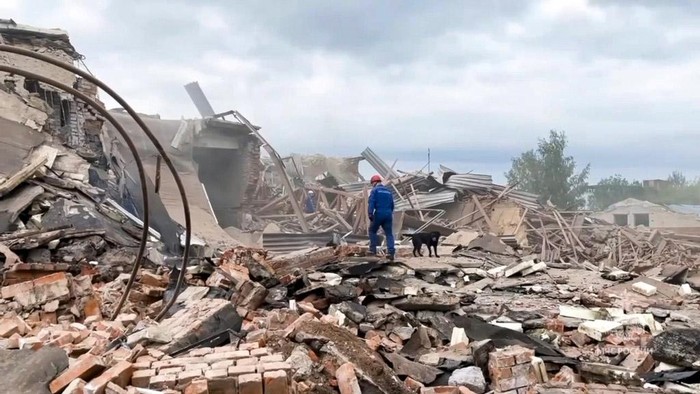 Pabrik di Rusia Meledak, Begini Potretnya In this photo released by Russian Emergency Ministry Press Service on Wednesday, Aug. 9, 2023, An emergency Ministry employee and his dog work at the side of the Zagorsk Optical and Mechanical Plant after the blast in the city of Sergiev Posad, Moscow Region, about 65 km (41miles) north-east of Moscow, Russia. An explosion Wednesday, on the grounds of a factory north of Moscow that makes optical equipment for Russia's security forces wounded dozens people, six of them severely, officials said. (Russian Emergency Ministry Press Service via AP)