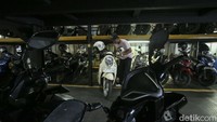 Tampak juru parkir menata sepeda motor dengan rapi.  