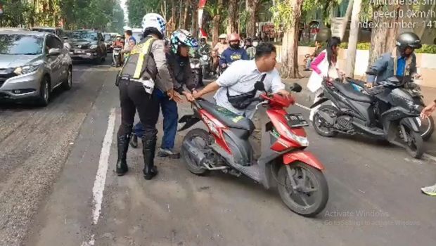 Pemotor tergelincir di Jalan Raya Darmo imbas debu pengaspalan yang belum tuntas.