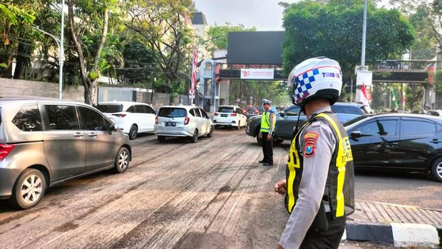Pengaspalan di Jalan Raya Darmo yang molor berimbas tergelincirnya pengendara motor dan penutupan jalan.