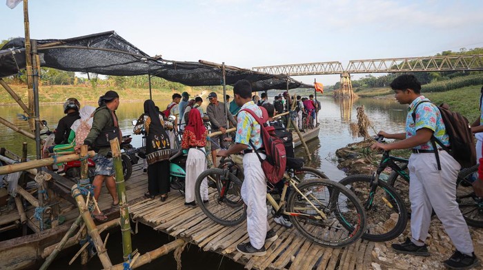 Warga antre menaiki perahu untuk menyebrangi Sungai Bengawan Solo di Desa Simo, Tuban, Jawa Timur, Kamis (10/8/2023). Perahu penyebrangan yang sempat ditutup tersebut kembali dioperasikan warga setempat sebagai jalur alternatif untuk melintasi Sungai Begawan Solo setelah jalur utama yakni Jembatan Glendeng ditutup untuk perbaikan. ANTARA FOTO/Rizal Hanafi/Spt.