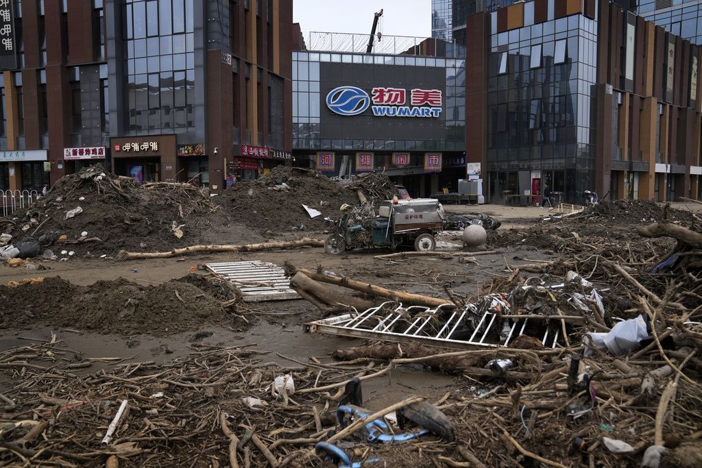 Floods debris are left over near a commercial office building in the aftermath of flood waters from an overflowing river in the Mentougou district on the outskirts of Beijing on Monday, Aug. 7, 2023. The death toll in recent flooding in China's capital rose, officials said Wednesday, as much of the country's north remains threatened by unusually heavy rainfall. (AP Photo/Andy Wong)