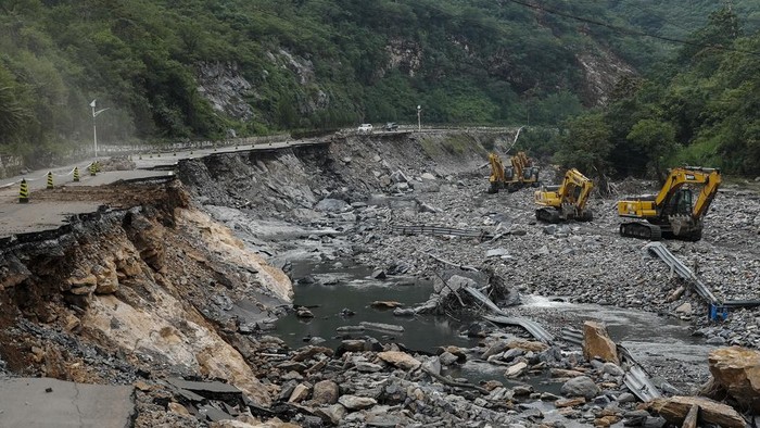 Potret Kerusakan Akibat Banjir di Beijing, Jumlah Korban Tewas Bertambah In this photo released by Xinhua News Agency, heavy machineries carry out restoration work near a collapsed road in the aftermath of flood waters from an overflowing river in Shijiaying Town of Fangshan District on the outskirts of Beijing on Aug. 6, 2023. The death toll in recent flooding in China's capital rose, officials said Wednesday, Aug. 9, as much of the country's north remains threatened by unusually heavy rainfall. (Ju Huanzong/Xinhua via AP)