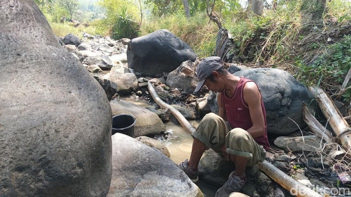 Pria asal Desa Padarama, Kabupaten Kuningan, Hasan (40) saat mencari ikan di aliran sungai yang mengering