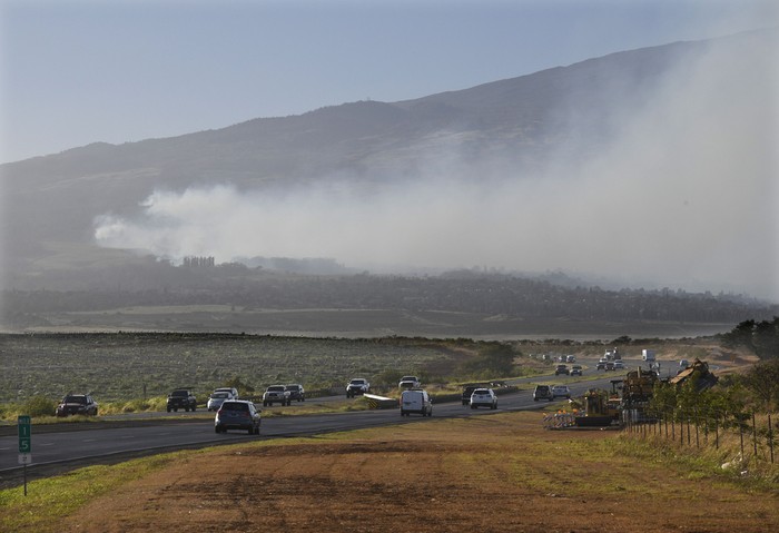 Smoke blows across the slope of Haleakala volcano on Maui, Hawaii, as a fire burns in Mauis upcountry region on Tuesday, Aug. 8. 2023. Several Hawaii communities were forced to evacuate from wildfires that destroyed at least two homes as of Tuesday as a dry season mixed with strong wind gusts made for dangerous fire conditions. (Matthew Thayer/The Maui News via AP)