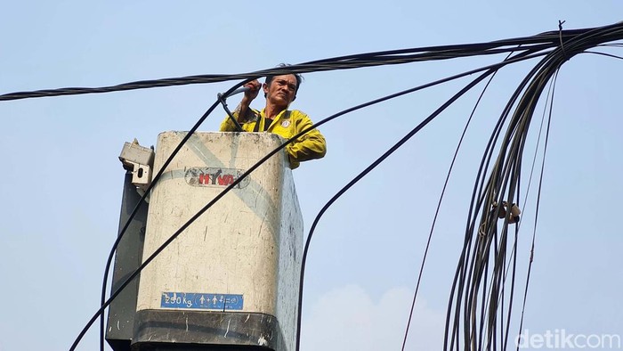 Aksi Petugas Tertibkan Kabel Semrawut di Menteng Petugas Dinas Bina Marga DKI Jakarta menata instalasi kabel yang semrawut di Jalan Yusuf Adiwinata, Menteng, Jakarta. Yuk lihat aksi mereka.